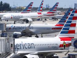 FILE - In this April 24, 2019, photo, American Airlines aircraft are shown parked at their gates at Miami International Airport in Miami. An American Airlines mechanic is accused of sabotaging a flight from Miami International Airport to Nassau in the Bahamas, over stalled union contract negotiations. Citing a criminal complaint affidavit filed in federal court, The Miami Herald reports Abdul-Majeed Marouf Ahmed Alani was arrested Thursday, Sept. 5, 2019, on the sabotage charge and is accused of disabling t