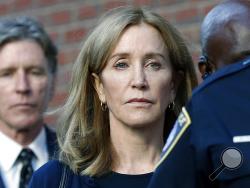 Felicity Huffman leaves federal court with her brother Moore Huffman Jr. following, after she was sentenced in a nationwide college admissions bribery scandal, Friday, Sept. 13, 2019, in Boston. (AP Photo/Michael Dwyer)