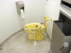 FILE - This Sept. 16, 2016 file image made from a video shows the 18-karat toilet, titled "America," by Maurizio Cattelan in the restroom of the Solomon R. Guggenheim Museum in New York. Thieves have stolen the solid gold toilet worth up to 1 million pounds from Blenheim Palace, the birthplace of Winston Churchill. The toilet, the work of Italian conceptual artist Maurizio Cattelan, had been installed only two days earlier at Blenheim Palace, west of London, after previously being on show at the Guggenheim 