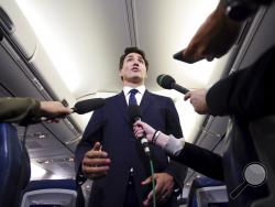 Canadian Prime Minister and Liberal Party leader Justin Trudeau makes a statement in regards to a photo coming to light of himself from 2001, wearing "brownface," during a scrum on his campaign plane in Halifax, Nova Scotia, Wednesday, Sept. 18, 2019. (Sean Kilpatrick/The Canadian Press via AP)