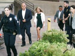 In this Tuesday, Sept. 24, 2019 photo, Amber Guyger, center, walks flanked by security while arriving for her murder trial at the Frank Crowley Courthouse in downtown Dallas. Security has been ramped up around the white former Dallas police officer’s high-profile trial for murder in the killing of her unarmed black neighbor. The Dallas Police Association says threats have forced the group to hire private security for Guyger and her lawyers. (AP Photo/LM Otero)