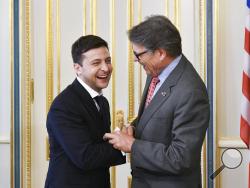 FILE - In this May 20, 2019, file photo, Ukrainian President Volodymyr Zelenskiy, left, and Energy Secretary Rick Perry share a joke during their meeting in Kiev, Ukraine. Michael Bleyzer and Alex Cranberg, two political supporters of Perry secured a potentially lucrative oil-and-gas exploration deal from the Ukrainian government soon after Perry proposed one of the men as an adviser to the country’s new president. (Mykola Lazarenko/Presidential Press Service Pool Photo via AP)