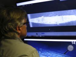 In this Wednesday, Oct. 16, 2019, photo, Vulcan Inc. director of subsea operations on the Petrel, Rob Kraft, left, looks at images of the Japanese aircraft carrier Kaga, off Midway Atoll in the Northwestern Hawaiian Islands. Deep-sea explorers scouring the world's oceans for sunken World War II ships are honing in on a debris field deep in the Pacific. Weeks of grid searches around the Northwestern Hawaiian Islands already have led the research vessel Petrel to one sunken battleship, the Japanese aircraft c