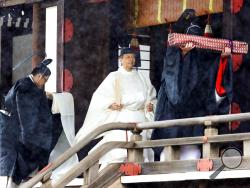 Japan's Emperor Naruhito, in a white robe, leaves after praying at “Kashikodokoro”, one of three shrines at the Imperial Palace, in Tokyo, Tuesday, Oct. 22, 2019. Emperor Naruhito visited three Shinto shrines at the Imperial Palace before proclaiming himself Japan’s 126th emperor in an enthronement ceremony. (Kyodo News via AP)