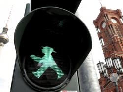 In this Tuesday, Oct. 22, 2019 photo a little traffic-light man is pictured in front of the Berlin TV Tower, left, and the 'Rotes Rathaus' (red townhall), right, in Berlin, Germany. Like many products of the east, the 'Ampelmaennchen', literally the 'little traffic light man', was nearly discarded after the fall of the wall. The slightly portly green figure with a wide-brimmed hat who told East Germans when they could cross the street faced strong competition from his taller, more sober counterpart in the W