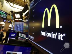 The logo for McDonald's appears above a trading post on the floor of the New York Stock Exchange, Monday, Nov. 4, 2019. McDonald's sank 2.3% after its CEO was ousted after violating company policy by having a relationship with an employee. (AP Photo/Richard Drew)