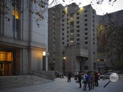 Reporters wait outside federal court for the exit of two jail guards, following their arraignment charge of falsifying prison records about their monitoring of Jeffrey Epstein the night he killed himself at the Metropolitan Correctional Center jail, center, Tuesday Nov. 19, 2019, in New York. (AP Photo/Bebeto Matthews)