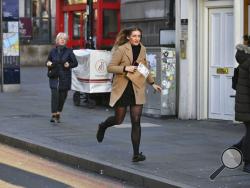 People are evacuated from London Bridge in central London following a police incident, Friday, Nov. 29, 2019. British police said Friday they were dealing with an incident on London Bridge, and witnesses have reported hearing gunshots. The Metropolitan Police force tweeted that officers were “in the early stages of dealing with an incident at London Bridge.” (Dominic Lipinski/PA via AP)