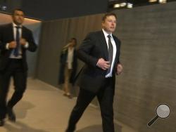 In this frame grab from video, Tesla CEO Elon Musk leaves court, Tuesday, Dec. 3, 2019, in Los Angeles. Musk denied that he meant to call a British cave diver a pedophile when he dubbed him "pedo guy" on social media. (AP Photo/Krysta Fauria)