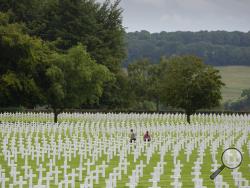 In this photo taken on Aug. 8, 2019, visitors walk among the headstones at the Henri Chapelle World War II cemetery in Henri Chapelle, Belgium. The cemetery contains 7,992 American war dead and covers 57 acres. It was 75 years ago that Hitler launched his last desperate attack to turn the tide for Germany in World War II. At first, German forces drove so deep through the front line in Belgium and Luxembourg that the month-long fighting came to be known as The Battle of the Bulge. (AP Photo/Virginia Mayo)