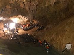 In this June 26, 2018, file photo, emergency rescue teams gather in the staging area as they continue the search for a young soccer team and their coach believed to be missing in a large cave in Mae Sai, Chiang Rai province, northern Thailand. A Thai navy SEAL who was part of the dramatic rescue of 12 boys and their soccer coach from the flooded cave has died of a blood infection contracted during the risky operation. 