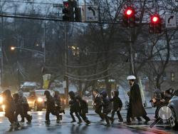 In this Monday, Dec. 30, 2019, photo, a group of orthodox Jewish children cross the street in Monsey, N.Y. With the rapid expansion of Orthodox communities outside New York City has come civic sparring, and some fear the recent violence in the area may be an outgrowth of that conflict. (AP Photo/Seth Wenig)