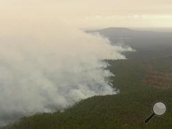 In this image made from video, an aerial view shows wildfires in the forests of Gippsland, Victoria, Australia, Dec. 31, 2019. Wildfires burning across Australia's two most-populous states have trapped residents of a seaside town in apocalyptic conditions, destroyed many properties and caused at least two fatalities. (Australian Broadcasting Corporation, Channel 7, Channel 9 via AP)