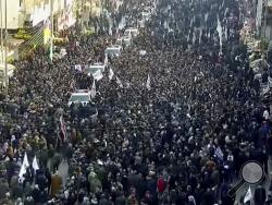 In this image made from a video, mourners gather for a funeral procession for Gen. Qassem Soleimani, in Baghdad Saturday, Jan. 4, 2020. The head of Iran's elite Quds force and mastermind of its regional security strategy, was killed in an airstrike early Friday near the Iraqi capital's international airport that has caused regional tensions to soar. (PMF Media Office via AP)