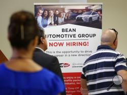 FILE - In this Sept. 18, 2019, file photo people stand in line to inquire about jobs available at the Bean Automotive Group during a job fair in Miami. On Friday, Jan. 10, 2020, the U.S. government issues the December jobs report. (AP Photo/Lynne Sladky, File)