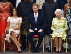 FILE - In this Tuesday, June 26, 2018 file photo Britain's Queen Elizabeth, Prince Harry and Meghan, Duchess of Sussex pose for a group photo at the Queen's Young Leaders Awards Ceremony at Buckingham Palace in London. In a stunning declaration, Britain's Prince Harry and his wife, Meghan, said they are planning "to step back" as senior members of the royal family and "work to become financially independent." A statement issued by the couple Wednesday, Jan. 8, 2020 also said they intend to "balance" their t