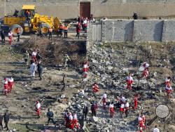 In this Wednesday, Jan. 8, 2020, photo, rescue workers search the scene where a Ukrainian plane crashed in Shahedshahr, southwest of the capital Tehran, Iran. Iran on Saturday, Jan. 11, acknowledged that its armed forces "unintentionally" shot down the Ukrainian jetliner that crashed earlier this week, killing all 176 aboard, after the government had repeatedly denied Western accusations that it was responsible. (AP Photo/Ebrahim Noroozi)