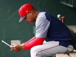 FILE - In this March 20, 2019, file photo, Boston Red Sox manager Alex Cora looks over the lineup before the team's spring training baseball game against the Baltimore Orioles in Sarasota, Fla. Cora was fired by the Red Sox on Tuesday, Jan. 14, 2020, a day after baseball Commissioner Rob Manfred implicated him in the sport's sign-stealing scandal. (AP Photo/John Bazemore)