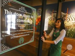 In this Wednesday, Jan. 15, 2020, photo, Belith Ariza, a barista trainer at Starbucks, opens the doors to the community meeting space at a local Starbucks Community Store, in Phoenix. The Seattle-based company plans to open or remodel 85 stores by 2025 in rural and urban communities across the U.S. That will bring to 100 the total number of community stores Starbucks has opened since it announced the program in 2015. (AP Photo/Ross D. Franklin)