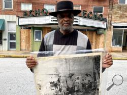 In this Monday, Jan. 13, 2020 photo, Rev. David Kennedy stands outside the Echo Theater holding a photo of his great uncle's lynching, in Laurens, S.C. Kennedy has fought for civil rights in South Carolina for decades. (AP Photo/Sarah Blake Morgan)