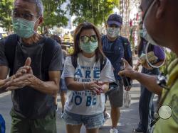 A doorman distributes hand sanitizing liquid for visitors at a luxury mall in Bangkok, Thailand, Tuesday, Jan. 28, 2020. Panic and pollution drive the market for protective face masks, so business is booming in Asia, where fear of the coronavirus from China is straining supplies and helping make mask-wearing the new normal. (AP Photo/Gemunu Amarasinghe)