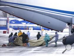 A group of medical personnel prepare to meet 80 people, accompanied by medical specialists, carried by a Russian military plane at an airport outside Tyumen, Russia, Wednesday, Feb. 5, 2020. Russia has evacuated 144 people, Russians and nationals of Belarus, Ukraine and Armenia, from the epicenter of the coronavirus outbreak in Wuhan, China, on Wednesday. All evacuees will be quarantined for two weeks in a sanatorium in the Tyumen region in western Siberia, government officials said. (AP Photo/Maxim Slutsky