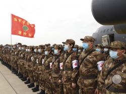 In this photo released by China's Xinhua News Agency, Chinese military medics arrive at the Tianhe International Airport in Wuhan, central China's Hubei Province, Feb. 13, 2020. China has mobilized its military resources in its fight against the COVID-19 viral outbreak. (Li Yun/Xinhua via AP)