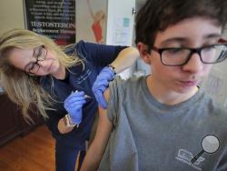 FILE - In this Jan. 3, 2019, file photo, Wendy Kerley gives Ethan Getman, 15, a shot of the flu vaccine at the Cordova Shot Nurse clinic in Memphis, Tenn. A second wave of flu is hitting the U.S., turning this into one of the nastiest flu seasons for children in a decade. (Jim Weber/Daily Memphian via AP, File)