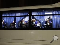 Buses carrying passengers from the quarantined Diamond Princess cruise ship leave a port in Yokohama, near Tokyo, Monday, Feb. 17, 2020. A group of Americans are cutting short a 14-day quarantine on the Diamond Princess cruise ship in the port of Yokohama, near Tokyo, to be whisked back to America. But they will have to spend another quarantine period at a U.S. military facility to make sure they don't have the new virus that's been sweeping across Asia. (AP Photo/Jae C. Hong)