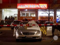 A car with dead bodies stands in front of a bar in Hanau, Germany, Thursday, Feb. 20, 2020. German police say several people were shot to death in the city of Hanau on Wednesday evening. (AP Photo/Michael Probst)