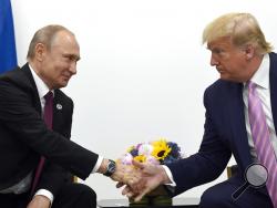 FILE - In this June 28, 2019, file photo, President Donald Trump, right, shakes hands with Russian President Vladimir Putin, left, during a bilateral meeting on the sidelines of the G-20 summit in Osaka, Japan. Intelligence officials say Russia is interfering with the 2020 election to try to help Trump get reelected, The New York Times reported Thursday, Feb. 20, 2020. (AP Photo/Susan Walsh, File)