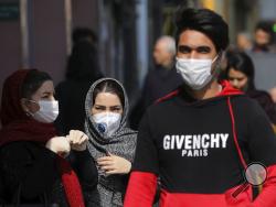 Pedestrians wear masks to help guard against the Coronavirus, in downtown Tehran, Iran, Sunday, Feb. 23, 2020. On Sunday Iran's health ministry raised the death toll from the new virus to 8 people in the country, amid concerns that clusters there, as well as in Italy and South Korea, could signal a serious new stage in its global spread. (AP Photo/Ebrahim Noroozi)
