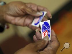 An election officer passes out "I Voted" stickers during the Super Tuesday primary at at Lincoln Terrace Elementary School. (Heather Rousseau/The Roanoke Times via AP)