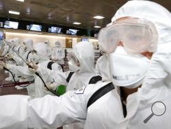 South Korean army soldiers wearing protective suits spray disinfectant to prevent the spread of the new coronavirus at Daegu International Airport in Daegu, South Korea, Friday, March 6, 2020. Seoul expressed “extreme regret” Friday over Japan’s ordering 14-day quarantines on all visitors from South Korea due to a surge in viral infections and warned of retaliation if Tokyo doesn’t withdraw the restrictions. (Kim Joo-sung/Yonhap via AP)