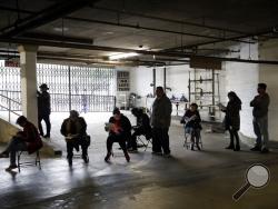 Unionized hospitality workers wait in line in a basement garage to apply for unemployment benefits at the Hospitality Training Academy Friday, March 13, 2020, in Los Angeles. Fearing a widespread health crisis, Californians moved broadly Friday to get in front of the spread of the coronavirus, shuttering schools that educate hundreds of thousands of students, urging the faithful to watch religious services online and postponing or scratching just about any event that could attract a big crowd. (AP Photo/Mar