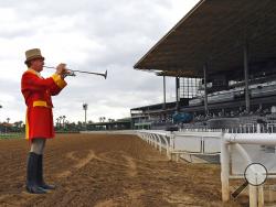 Bugler Jay Cohen plays "First Call" as he calls the riders to post for the first race at Santa Anita Park to empty stands Saturday, March 14, 2020, in Arcadia, Calif. While most of the sports world is idled by the coronavirus pandemic, horse racing runs on. (AP Photo/Mark J. Terrill)