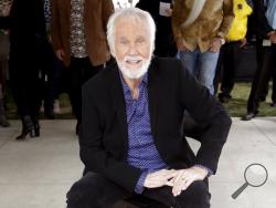 FILE - In this Oct. 24, 2017 file photo, Kenny Rogers poses with his star on the Music City Walk of Fame in Nashville, Tenn. Actor-singer Kenny Rogers, the smooth, Grammy-winning balladeer who spanned jazz, folk, country and pop with such hits as “Lucille,” “Lady” and “Islands in the Stream” and embraced his persona as “The Gambler” on record and on TV died Friday night, March 20, 2020. He was 81. (AP Photo/Mark Humphrey, File)