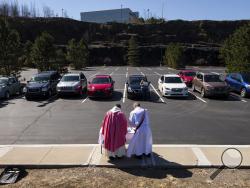 Rev. William A. Mentz, pastor of the Scranton, Pa. based St. Francis and Clare Progressive Catholic Church, and church deacon Frank Gillette celebrate a Catholic mass for the faithful sitting in their cars in a parking lot at the Shoppes at Montage in Moosic, Pa. on Sunday, March 22, 2020. The Progressive Catholic Church is a small denomination operating independently of the Roman Catholic Church. Other Catholic churches in the Scranton area suspended the celebration of mass to help control the spread of CO