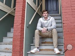 Cameron Karosis, 27, a software salesman, poses for a portrait outside his home, Tuesday, April 14, 2020, in Cambridge, Mass. Karosis usually strives to protect his personal information. But a scary bout with COVID-19 that began with headaches and fevers, progressed to breathing problems and led to a hospital visit has now left him eager to disclose as much as possible to help halt the virus' spread. “I’m sick and I’m under a quarantine -- hold me accountable for it,” he said. “You have the potential to kil