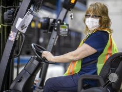 This photo provided by Cindy Parkhurst. shows Cindy Parkhurst working at the Ford Flat Rock Assembly Plant in Flat Rock, Mich. Like hundreds of workers at Ford, General Motors, Toyota and other companies, Parkhurst has gone back to work to make face shields, surgical masks and even ventilators in a wartime-like effort to stem shortages of protective gear and equipment during the coronavirus pandemic.(Cindy Parkhurst via AP)