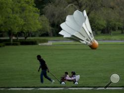 FILE - In this April 25, 2020, file photo, a man walks with his children at the Nelson-Atkins Museum of Art, in Kansas City, Mo. The museum remains closed as extended stay-at-home orders continue until May 15 in the city as part of an effort to stem the spread of the new coronavirus. (AP Photo/Charlie Riedel, File)