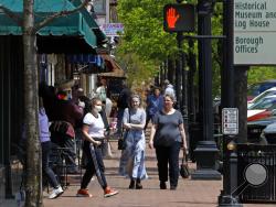 People gather outside shops in Beaver, Pa., Tuesday, May 12, 2020. Beaver County Commissioners have said they disagree with Pennsylvania Governor Tom Wolf and the county will act as if they are transitioning to the "yellow" phase on May 15. Pennsylvania Governor Tom Wolf announced, May 8, that 13 southwestern Pennsylvania counties, not including Beaver County, that would remain in the "red" phase where the stay-at-home order is still in effect, would move to the "yellow" phase on May 15. (AP Photo/Gene J. P