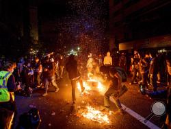Demonstrators burn garbage in Oakland, Calif., on Friday, May 29, 2020, while protesting the Monday death of George Floyd, a handcuffed black man in police custody in Minneapolis. (AP Photo/Noah Berger)