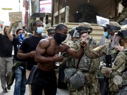 Demonstrators greet members of the National Guard as they march along Hollywood Boulevard, Tuesday, June 2, 2020, in the Hollywood section of Los Angeles, during a protest over the death of George Floyd, who died May 25 after he was restrained by Minneapolis police. (AP Photo/Ringo H.W. Chiu)