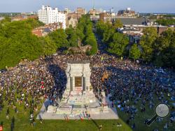 FILE - This Tuesday, June 2, 2020 file photo shows a large group of protesters gather around the statue of Confederate General Robert E. Lee on Monument Avenue near downtown in Richmond, Va. Virginia Gov. Ralph Northam is expected to announce plans Thursday for the removal of an iconic statue of Confederate Gen. Robert E. Lee from Richmond's prominent Monument Avenue. (AP Photo/Steve Helber, File)