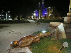 The statue of Confederate Gen. Williams Carter Wickham lies on the ground after protesters pulled it down Saturday, June 6, 2020, in Monroe Park in Richmond, Va. The statue had stood in the park since 1891. (Alexa Welch Edlund/Richmond Times-Dispatch via AP)