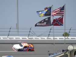 FILE - In this July 4, 2015, file photo, U.S., Confederate and Dale Earnhardt Sr. and Jr. flags fly near Turn 4 during NASCAR qualifying at Daytona International Speedway in Daytona Beach, Fla. NASCAR banned the Confederate flag from its races and venues Wednesday, June 10, 2020, formally severing itself from what for many is a symbol of slavery and racism. (AP Photo/Phelan M. Ebenhack, File)