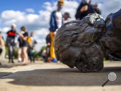 People stand around the fallen Christopher Columbus statue at the Minnesota state Capitol in St. Paul, Minn., Wednesday, June 10, 2020. (Evan Frost/Minnesota Public Radio via AP)