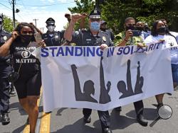 In this Saturday, May 30, 2020, photo, Camden County Metro Police Chief Joe Wysocki raises a fist while marching with Camden residents and activists in Camden, N.J., to protest the death of George Floyd in Minneapolis. Police officers in one of New Jersey's largest and most violent cities were praised on social media for marching alongside protesters in rallies held this weekend over Floyd's death. (April Saul via AP)