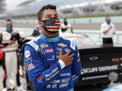 Bubba Wallace stands for the national anthem before a NASCAR Cup Series auto race Sunday, June 14, 2020, in Homestead, Fla. (AP Photo/Wilfredo Lee)